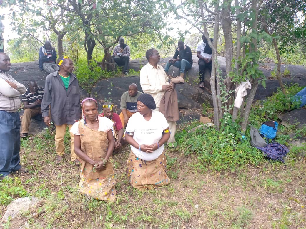 Le chef Kipamba de la tribu Hadzabe dirige l'équipe d'experts forestiers et les villageois dans une prière aux ancêtres avant de commencer la PFRA. (Crédit photo : FIDA Tanzanie)