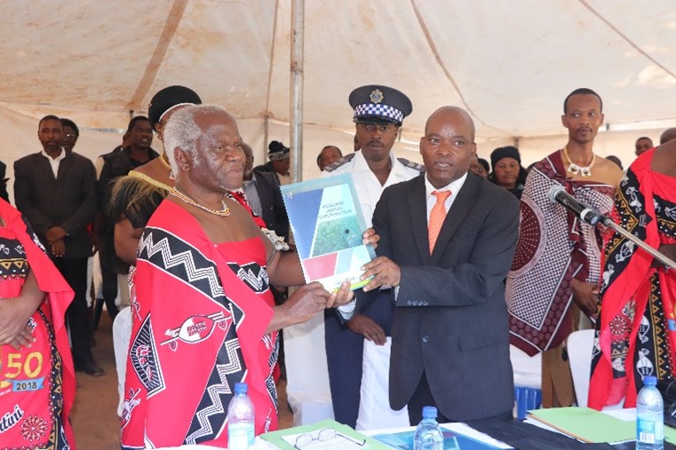 Chief Dambuza Lukhele of Ngobolweni Chiefdom, in Swazi attire, showing his subjects the Chiefdom Development Plan (CDP) - A Road Map for sustainable development during its launch. (Photo Credit: Norman Mavuso, SMLP Social Facilitation Manager)