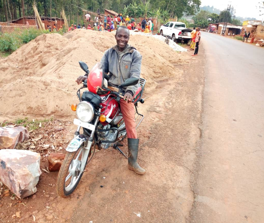 Ntahondereye Silas avec une moto qu'il a achetée trois saisons après avoir participé au FFS local. (FAO Burundi)